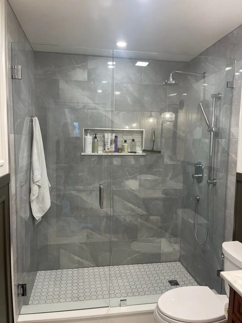 Walk-in shower remodel with large-format gray tile and recessed niche — Fenelon Handyman Services, Tampa Bay, FL