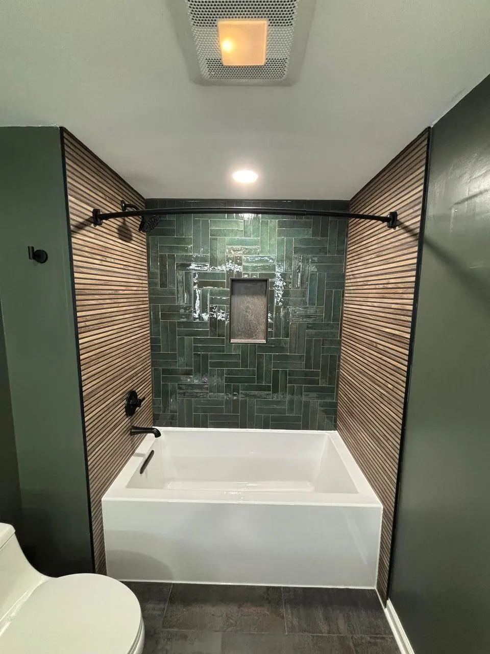 Bathtub surround remodel with green herringbone tile and matte black fixtures — Fenelon Handyman Services, Tampa Bay, FL