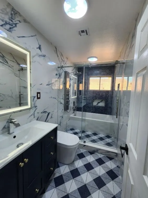 Finished bathroom remodel with navy vanity, checkered tile floor and glass shower — Fenelon Handyman Services, Tampa Bay, FL