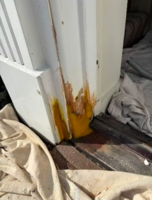 Two-part epoxy wood filler sculpted to the profile of a rotted exterior door frame during a Tampa door jamb rot repair, before sanding